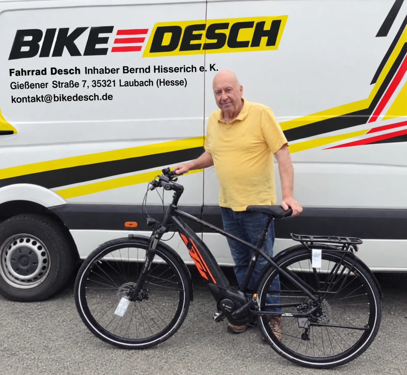 Client en polo jaune avec son vélo noir livré